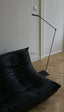 Contemporary black faux leather sofa chair in an industrial setting.