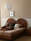 Wooden platform bed with dual circular rattan headboard panels