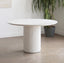 Round white terrazzo dining table with speckled surface