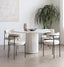 Round white terrazzo dining table with speckled surface