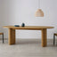 Oval light wood dining table with fluted legs