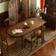 Oval wooden dining table with turned legs on geometric patterned rug