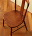 Solid wood dining chair with turned legs and vintage charm.