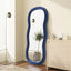 Blue wave-shaped full-length dressing mirror against a modern interior